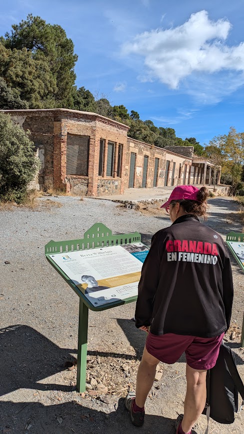 Guía de Granada en Femenino leyendo panel explicativo en entorno histórico