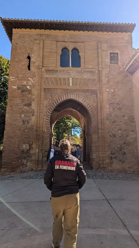 Guía de Granada en Femenino frente a puerta histórica nazarí