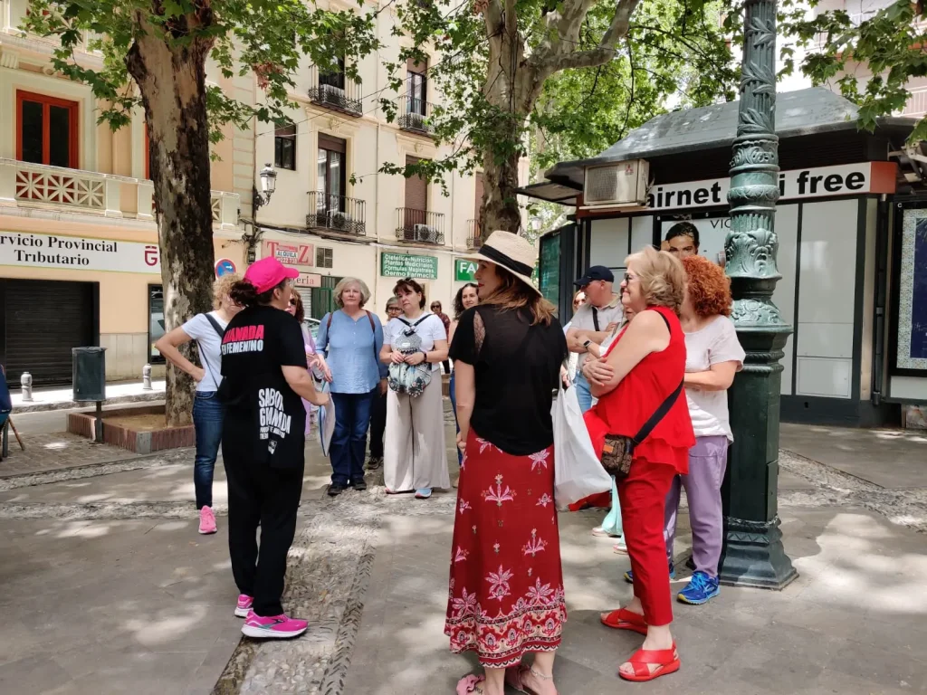Grupo escuchando guía de Granada en Femenino en plaza de la ciudad